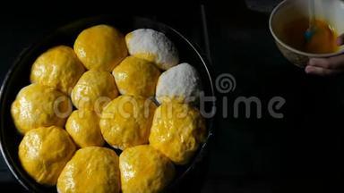 自制的烘焙片上，女面包师用鸡蛋将面团中的丸子涂成玫瑰色